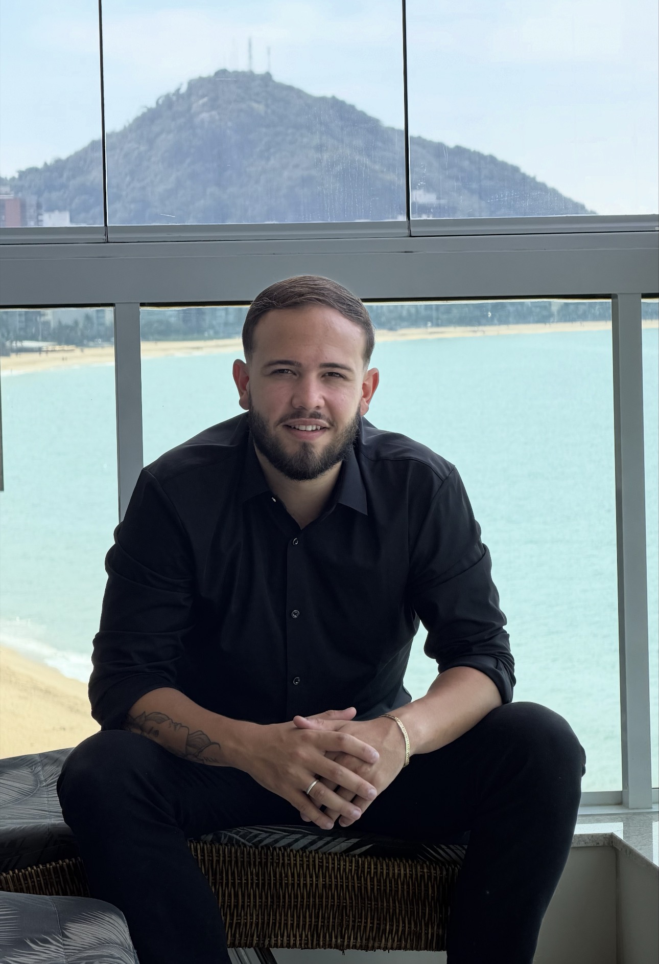 Lucas Carvalho em varanda de apartamento frente mar em Vila Velha